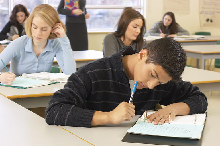 student working in notebook in classroom