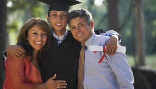 male graduate with arms around each parent