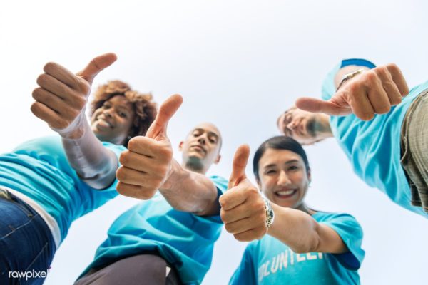 Thumbs up from four people wearing volunteer tshirts