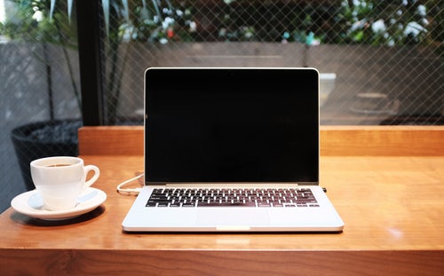 coffee cup next to laptop used to search for online resources for college admission