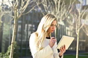 High school student w phone and iPad on campus