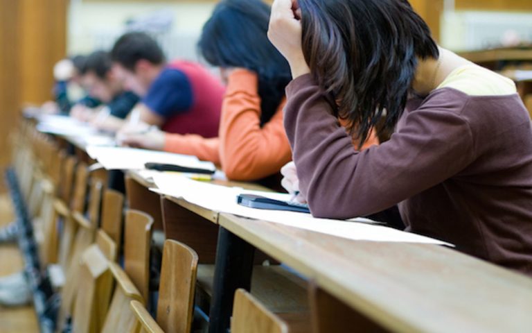 Students taking test at row of desks