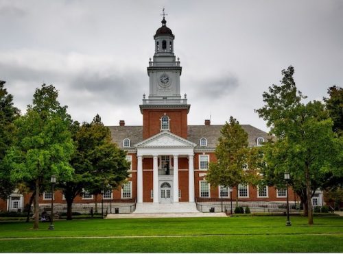 Red brick building with white pillars on college campus