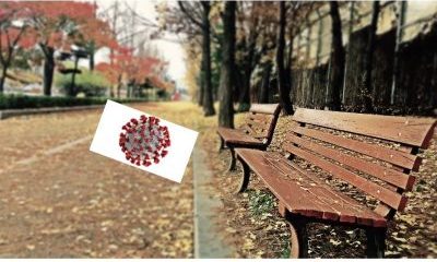 empty bench with fall leaves and coronavirus image