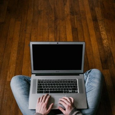 Close up of person holding laptop on lap