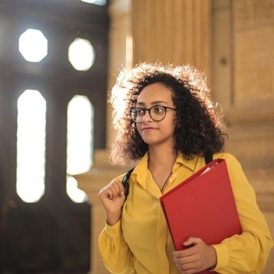 young woman holding binder in college building