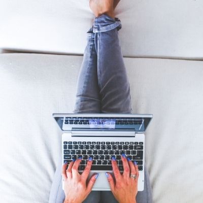 laptop resting on lap with legs propped up