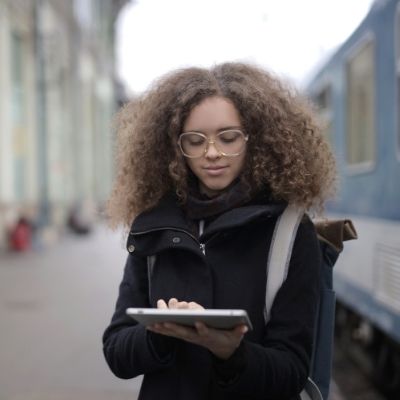 Young woman outside building looking at tablet