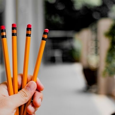 hand holding up 4 pencils