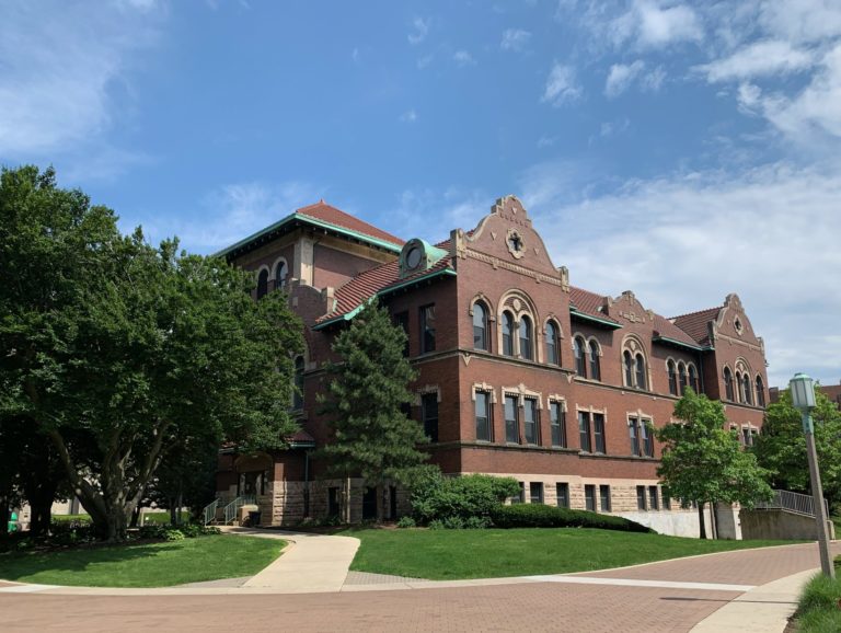 red brick college building with paths leading to it