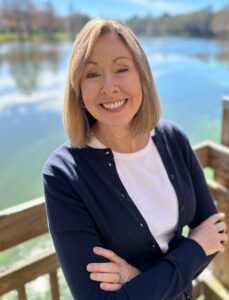 headshot of woman standing in front of a lake