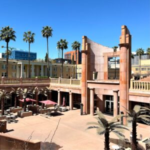 View of Arizona State University campus with palm trees, building and blue sky.